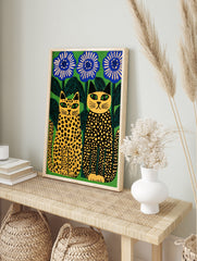 Stylised illustration of two spotted cats sitting beside large blue flowers against a vibrant, in an alternate framed mockup