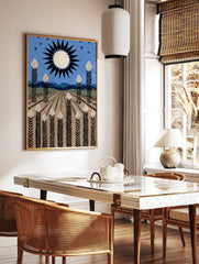 Stylised field art print with white-topped plants, black sun, blue sky, and distant mountains, in a styled room mockup