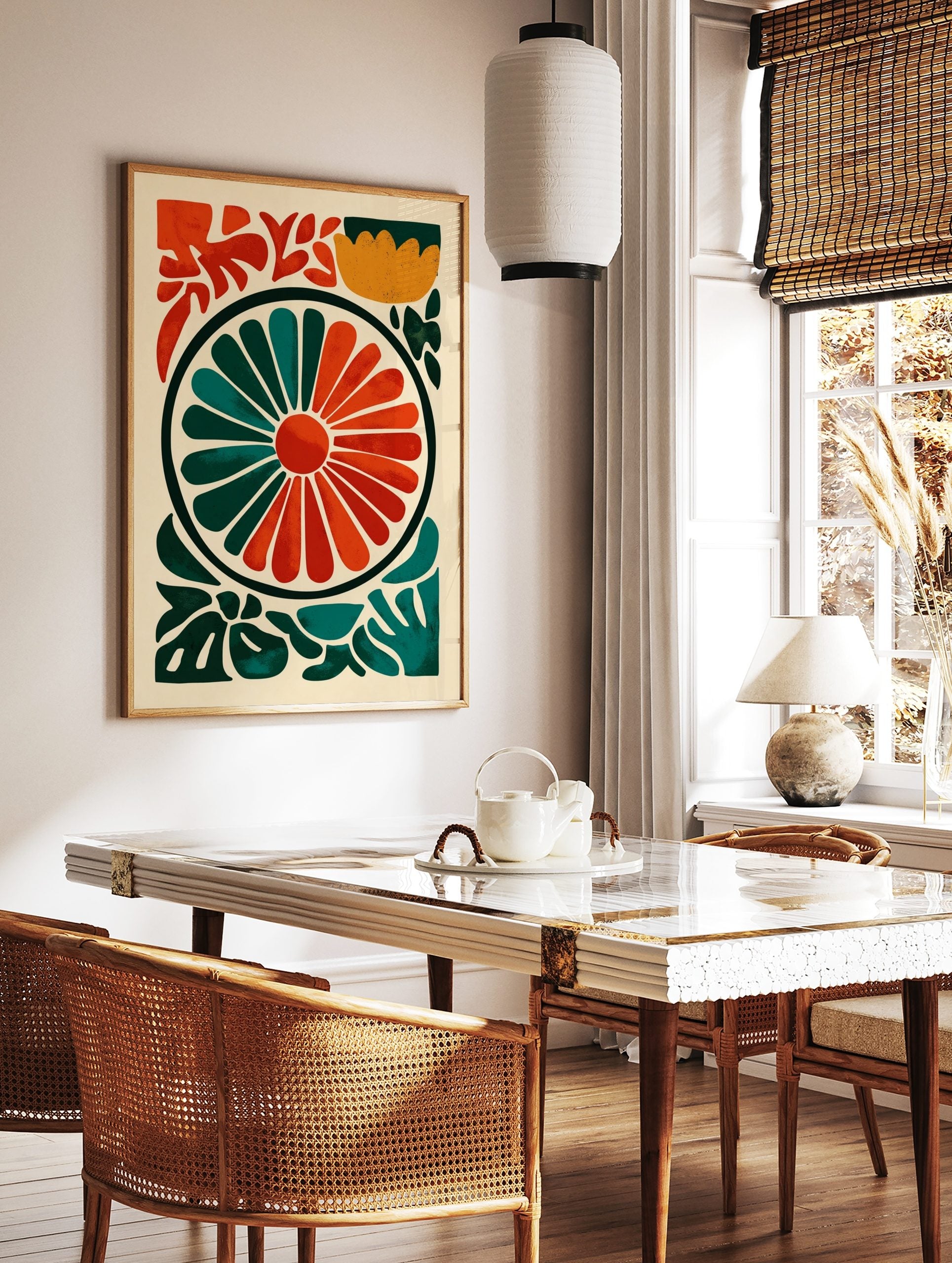 Abstract floral wheel art print with radiating orange and teal segments, surrounded by green, in a styled room mockup