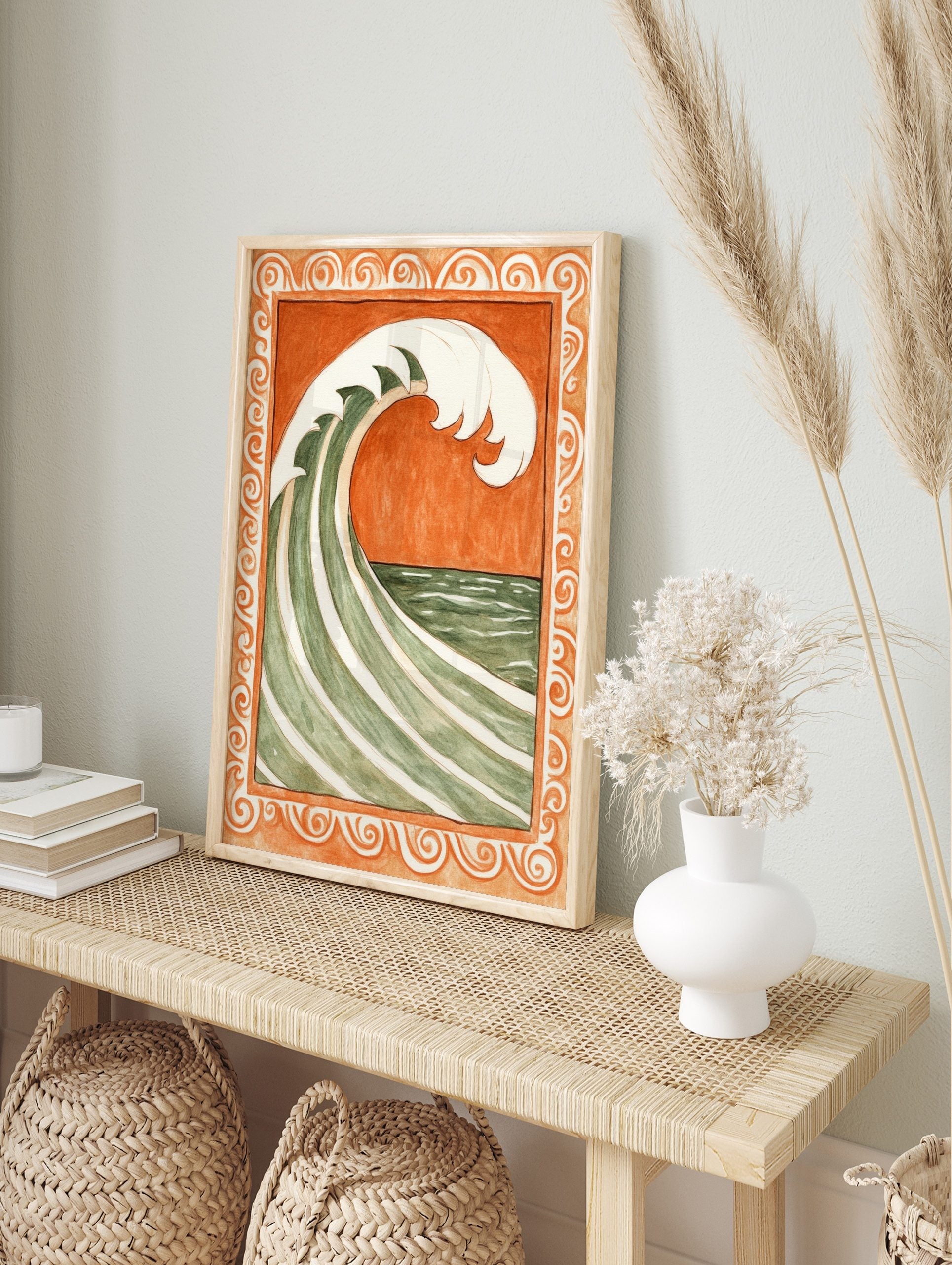 Stylised green and white ocean wave against burnt orange background, within ornate scrollwork, in an alternate framed mockup