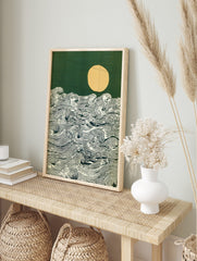 Stylised ocean waves with detailed lines, a pale yellow moon, and a dark green sky art print, in an alternate framed mockup