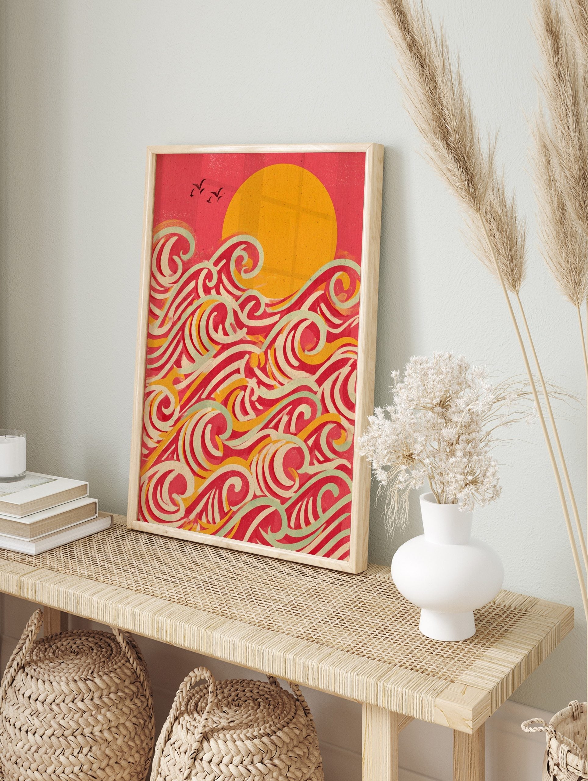 Stylised ocean waves wall art with a large golden sun, red sky, and layered waves in red, in an alternate framed mockup