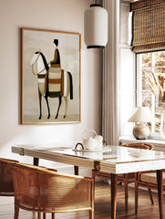 Stylised abstract art print of a rider on a horse in earth tones, black, and white, in a styled room mockup