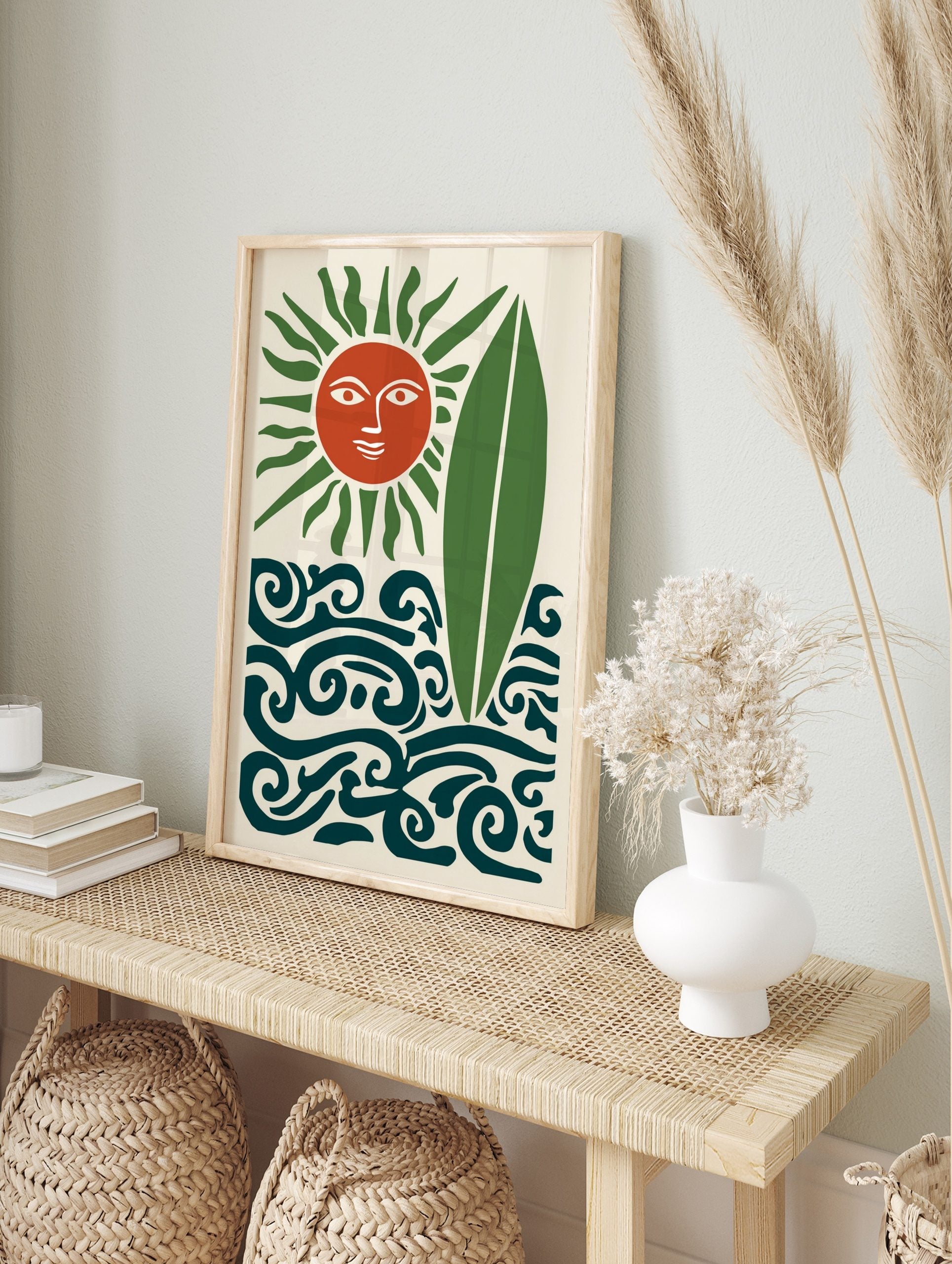 Stylised terracotta sun with green rays, green surfboard, and dark teal waves on a cream, in an alternate framed mockup