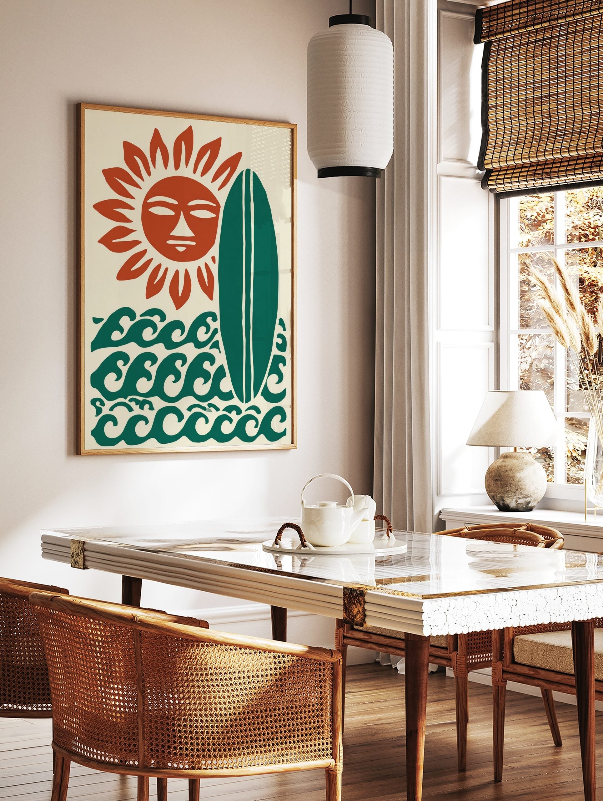 Stylised sun with a face, green surfboard, and ocean waves on a cream background art print, in a styled room mockup