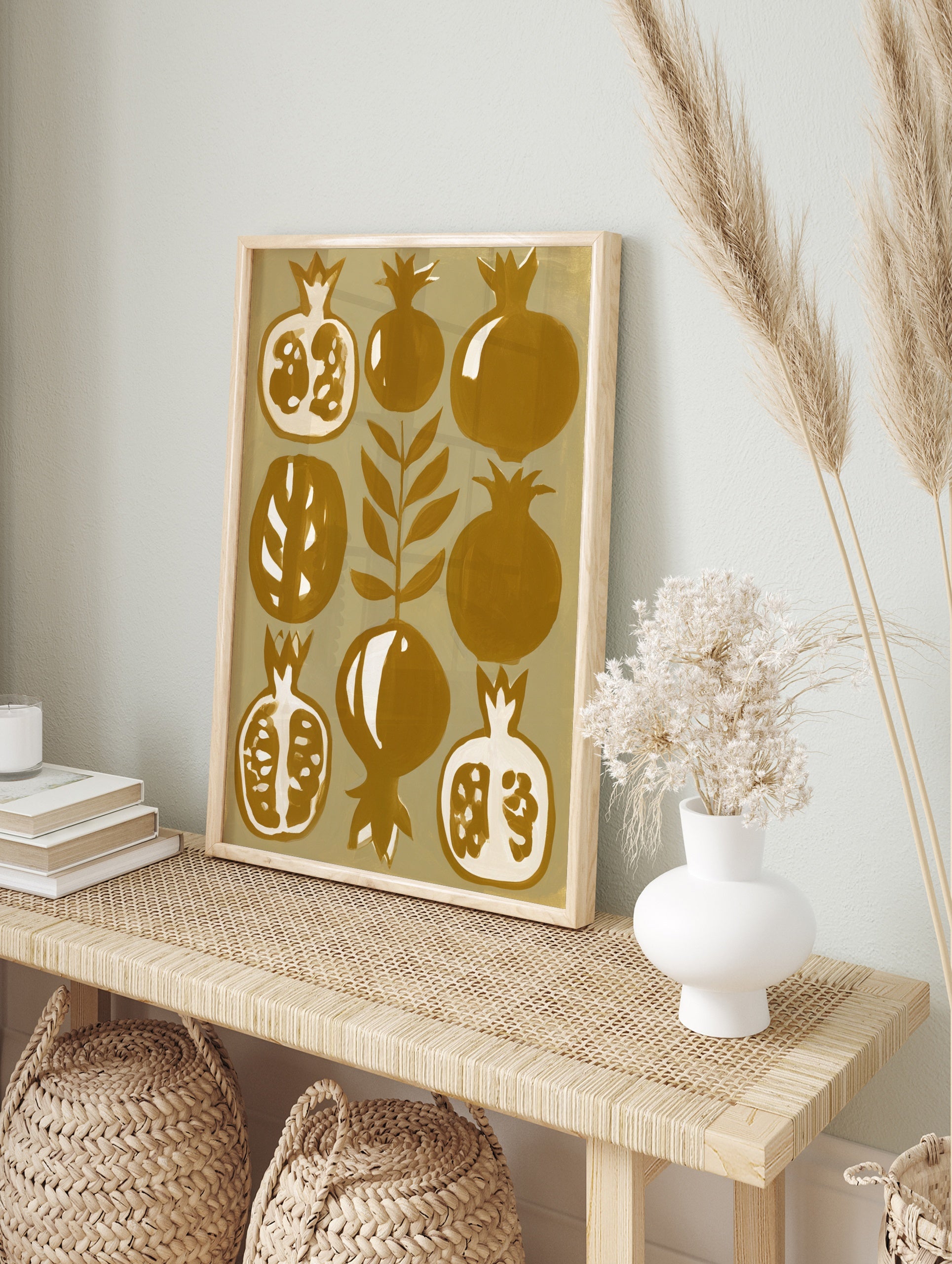 Stylized botanical pomegranate fruit illustration in mustard yellow and cream on paper wall, in an alternate framed mockup