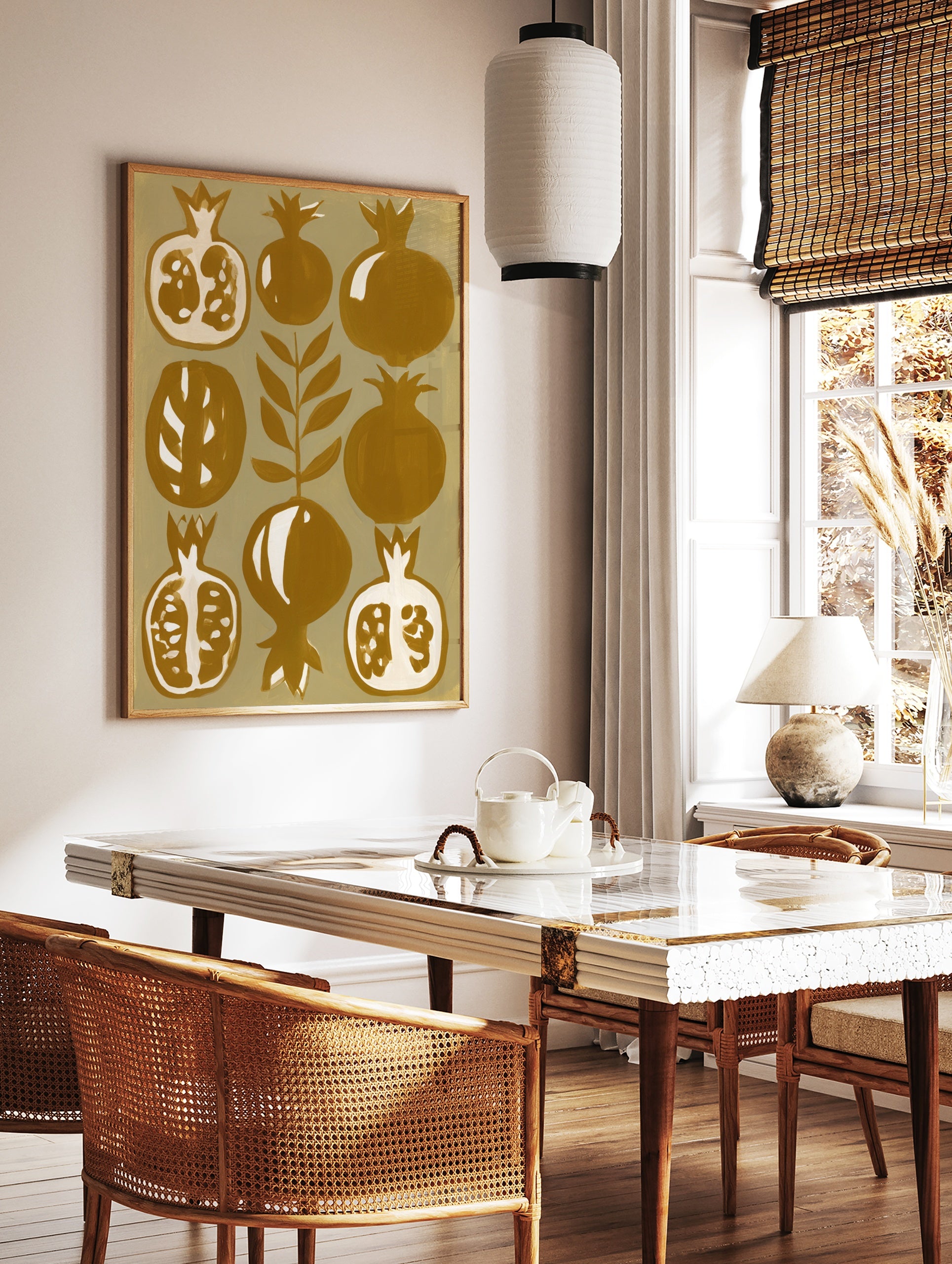Stylized botanical pomegranate fruit illustration in mustard yellow and cream on paper wall art, in a styled room mockup