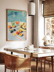 Illustrative summer still life with peaches, wine, water glass, sunglasses, and hat by a blue pool, in a styled room mockup