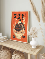 Illustrative print of a sumo wrestler in a ramen bowl with steam, Japanese text, and orange, in an alternate framed mockup