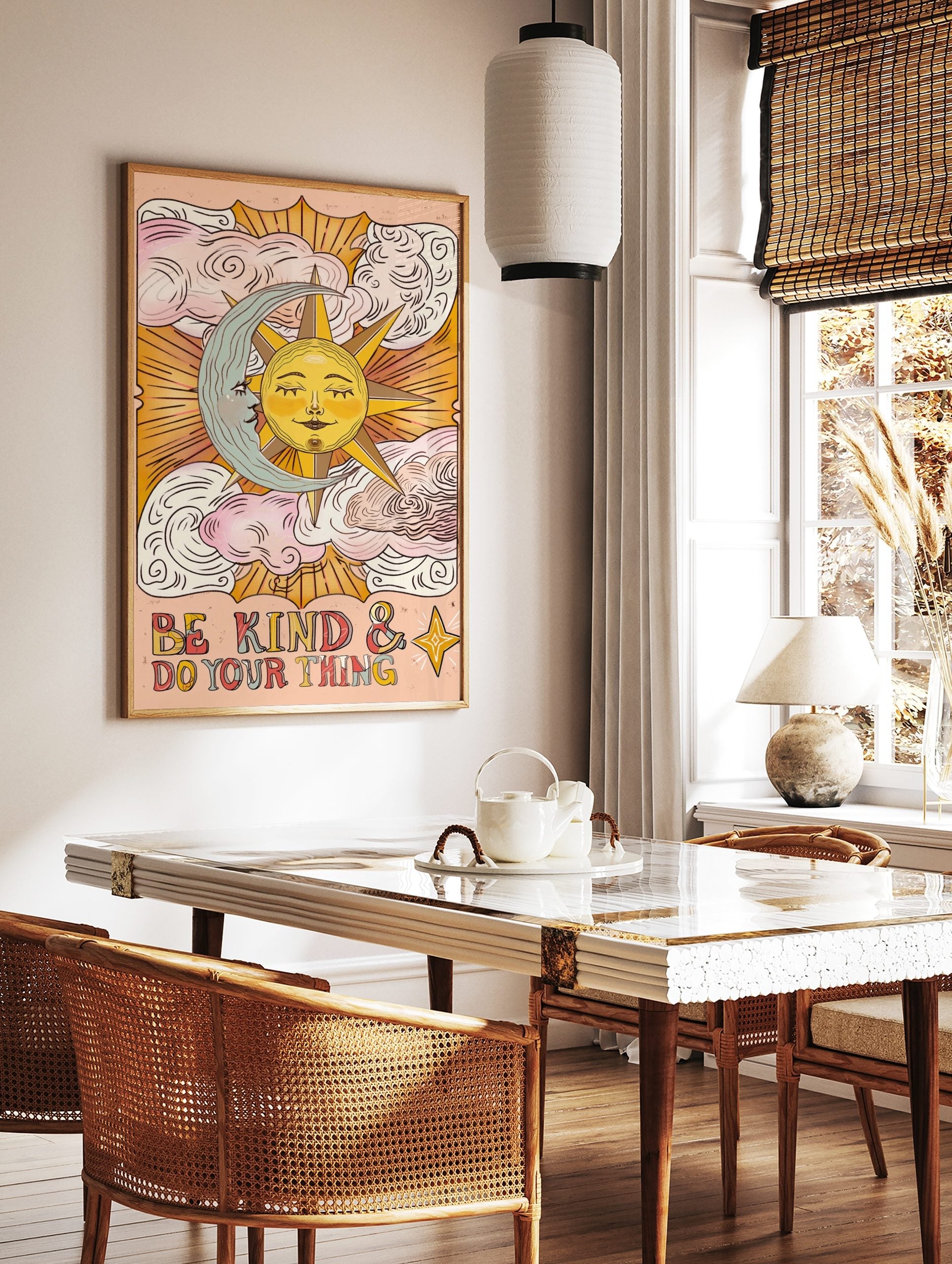 Celestial sun and moon wall art with 'Be Kind & Do Your Thing' text and clouds on a peach background, displayed as the same artwork in a styled poster mockup for home decor