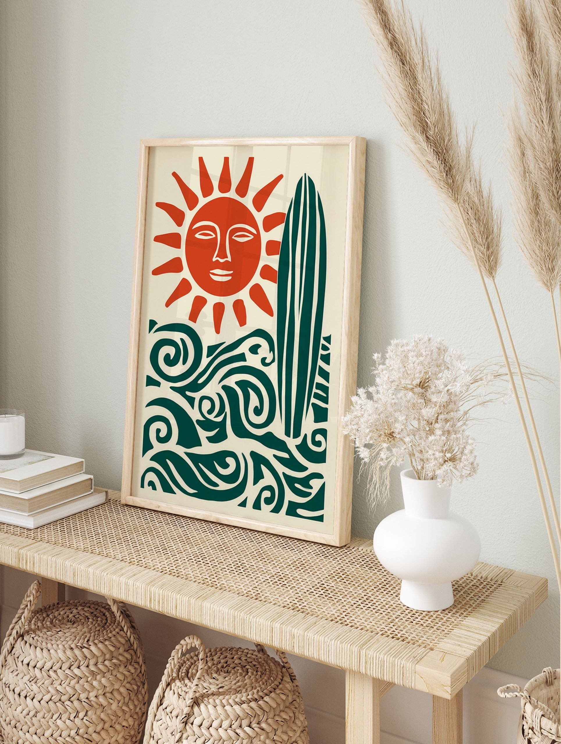 Illustrative sun with face, surfboard, and ocean waves in deep teal and burnt orange on cream, in an alternate framed mockup