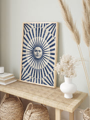 Classical sun face illustration with blue and beige radiating stripes art print, in an alternate framed mockup