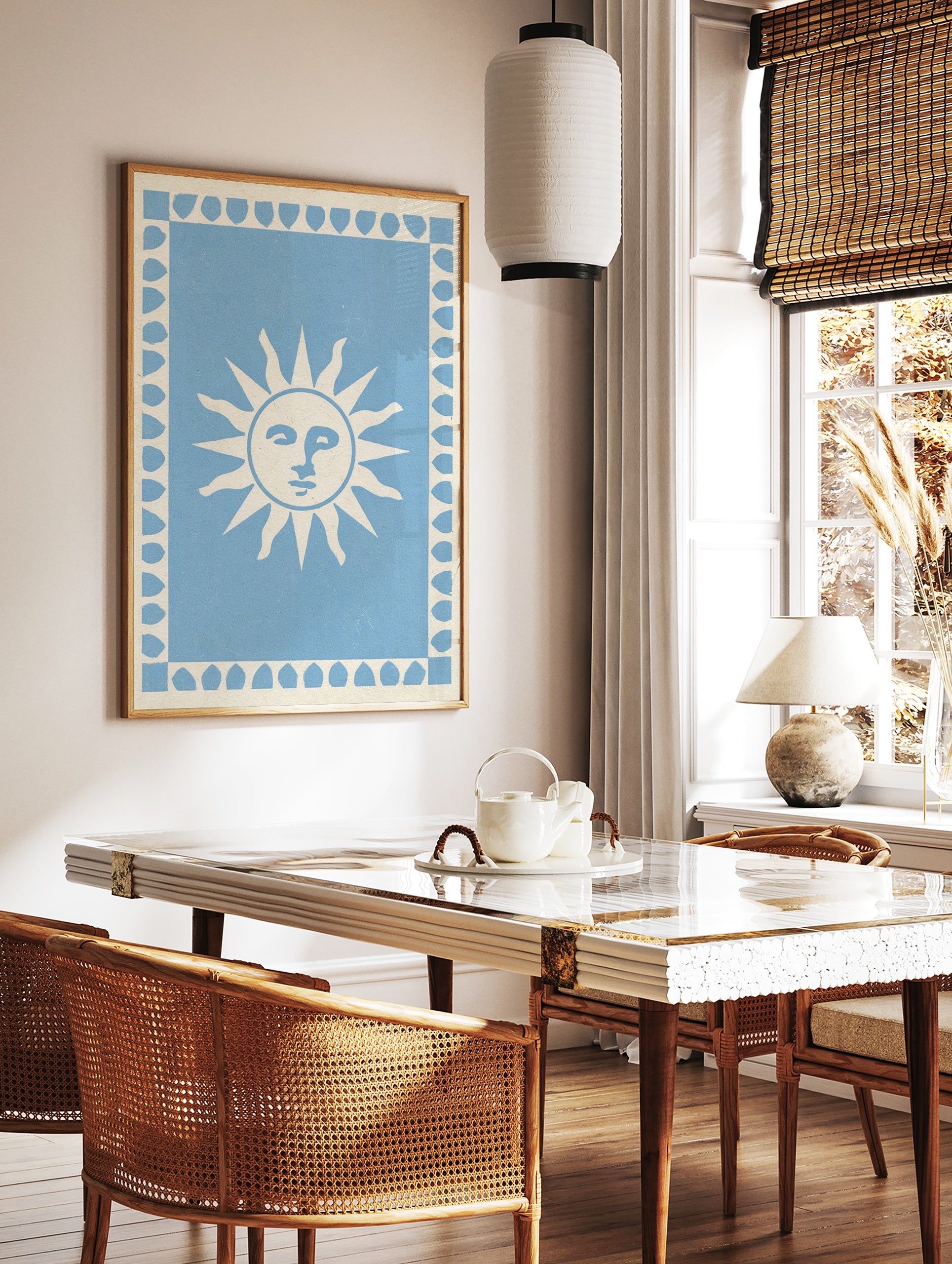 Stylized sun face illustration with a leaf border on a light blue background, art print, in a styled room mockup