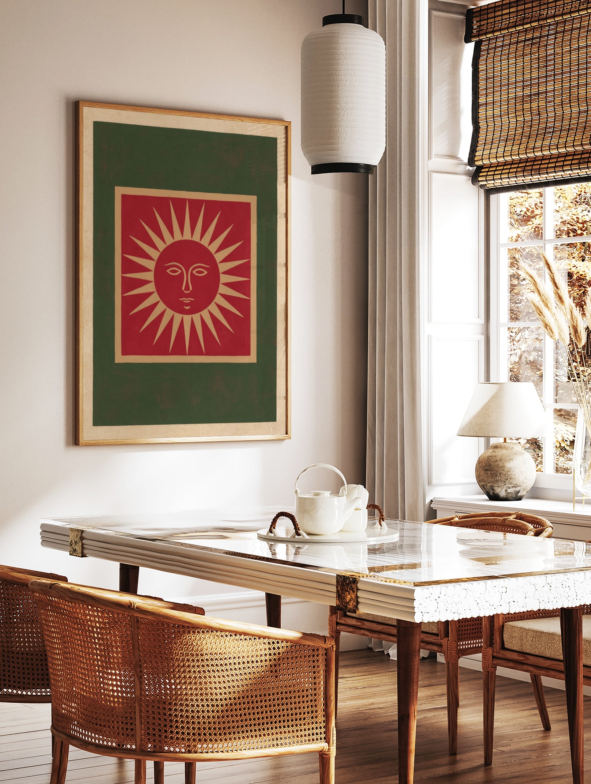 Illustrative red sun face wall art print with tan and green borders on a cream background, in a styled room mockup