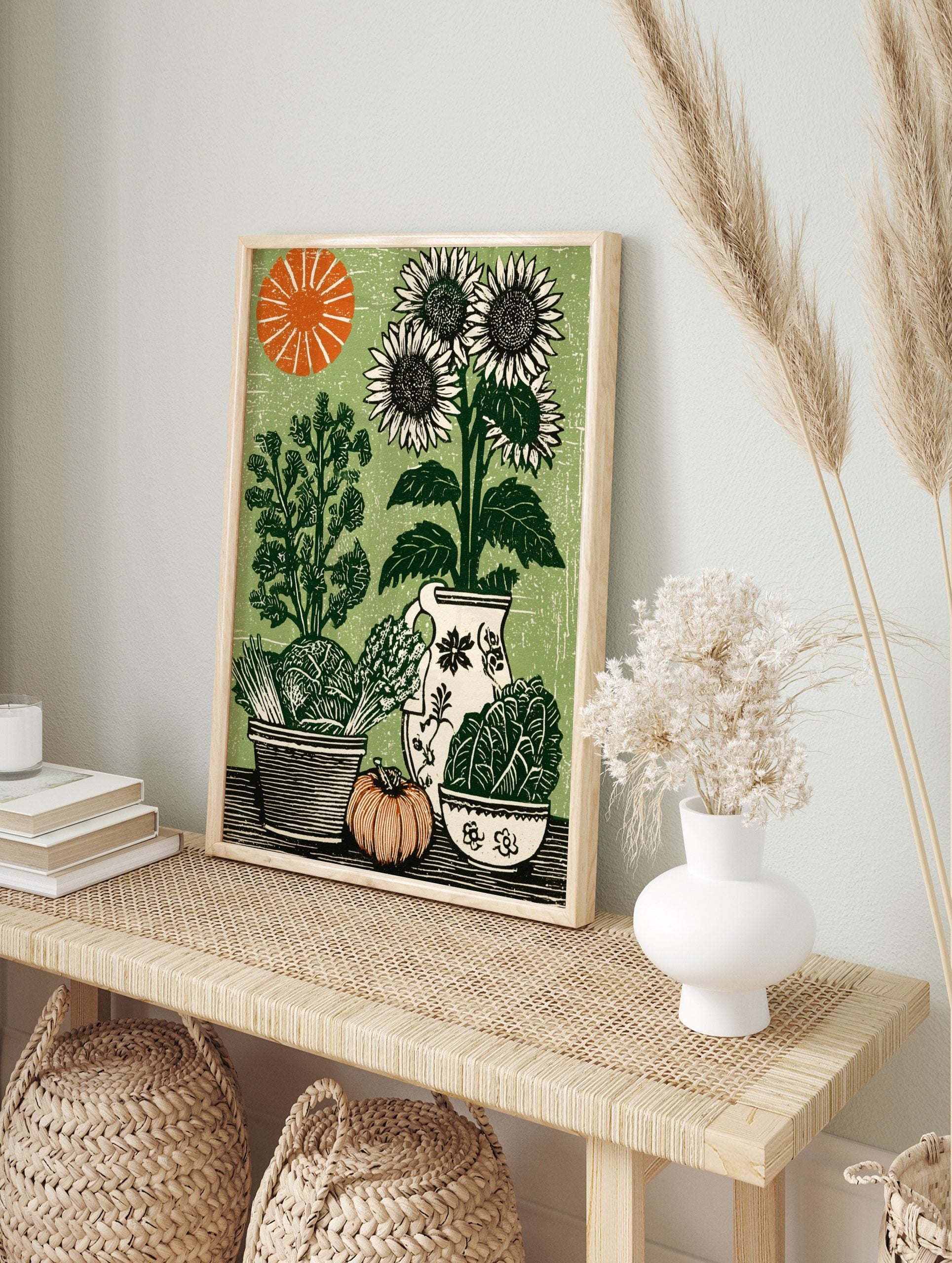 Woodcut style print of sunflowers, cabbage, asparagus, pumpkin, and pitcher on a green, in an alternate framed mockup