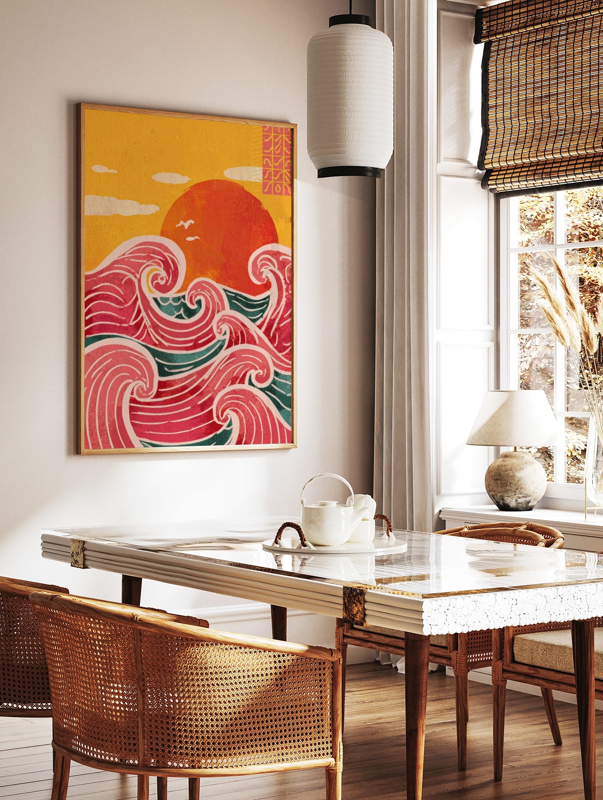 Illustrative print of a large red sun over stylised pink and teal ocean waves with a yellow sky, in a styled room mockup