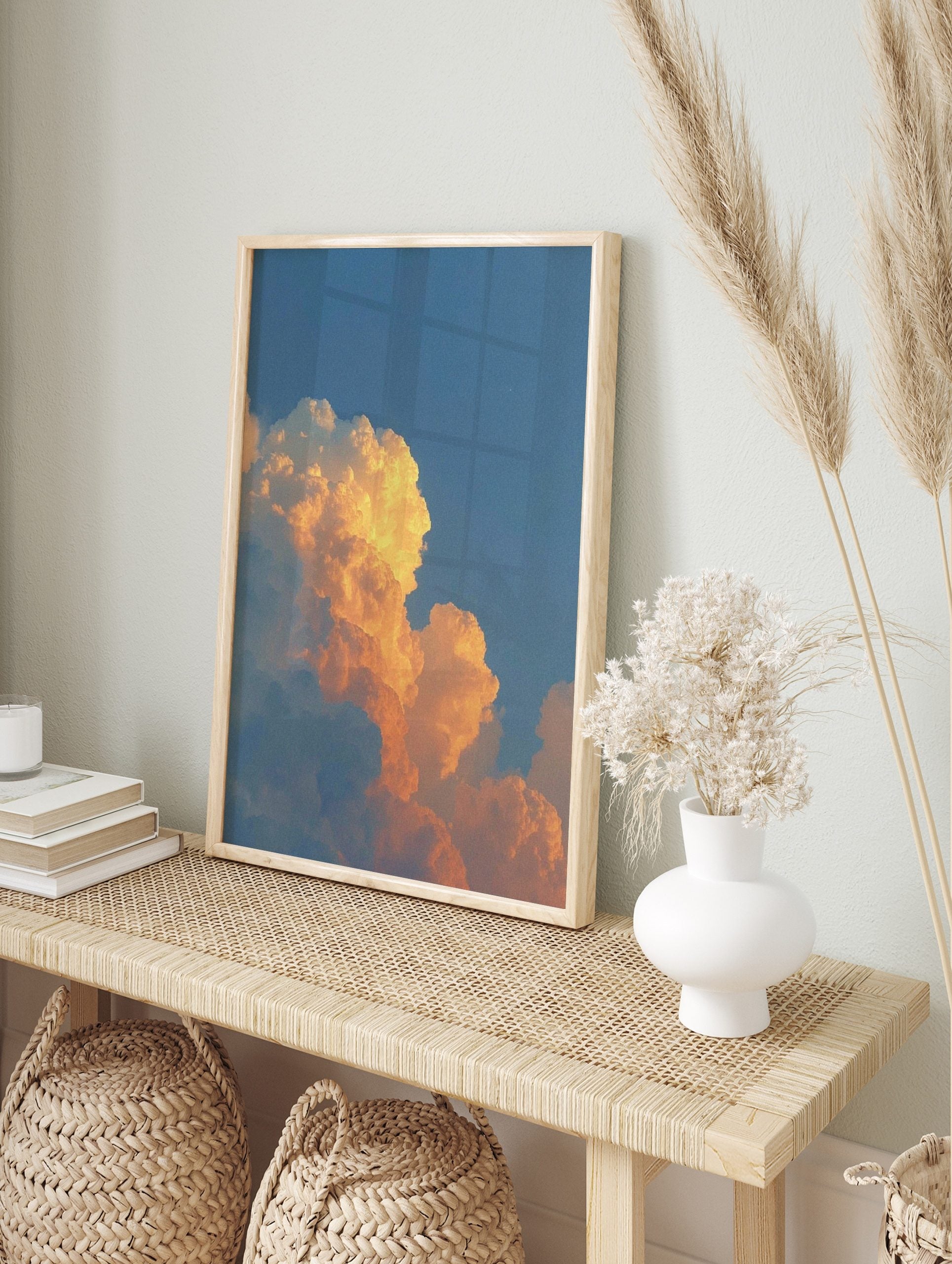 Dramatic orange and golden cumulus clouds against a clear blue sky during sunset, in an alternate framed mockup