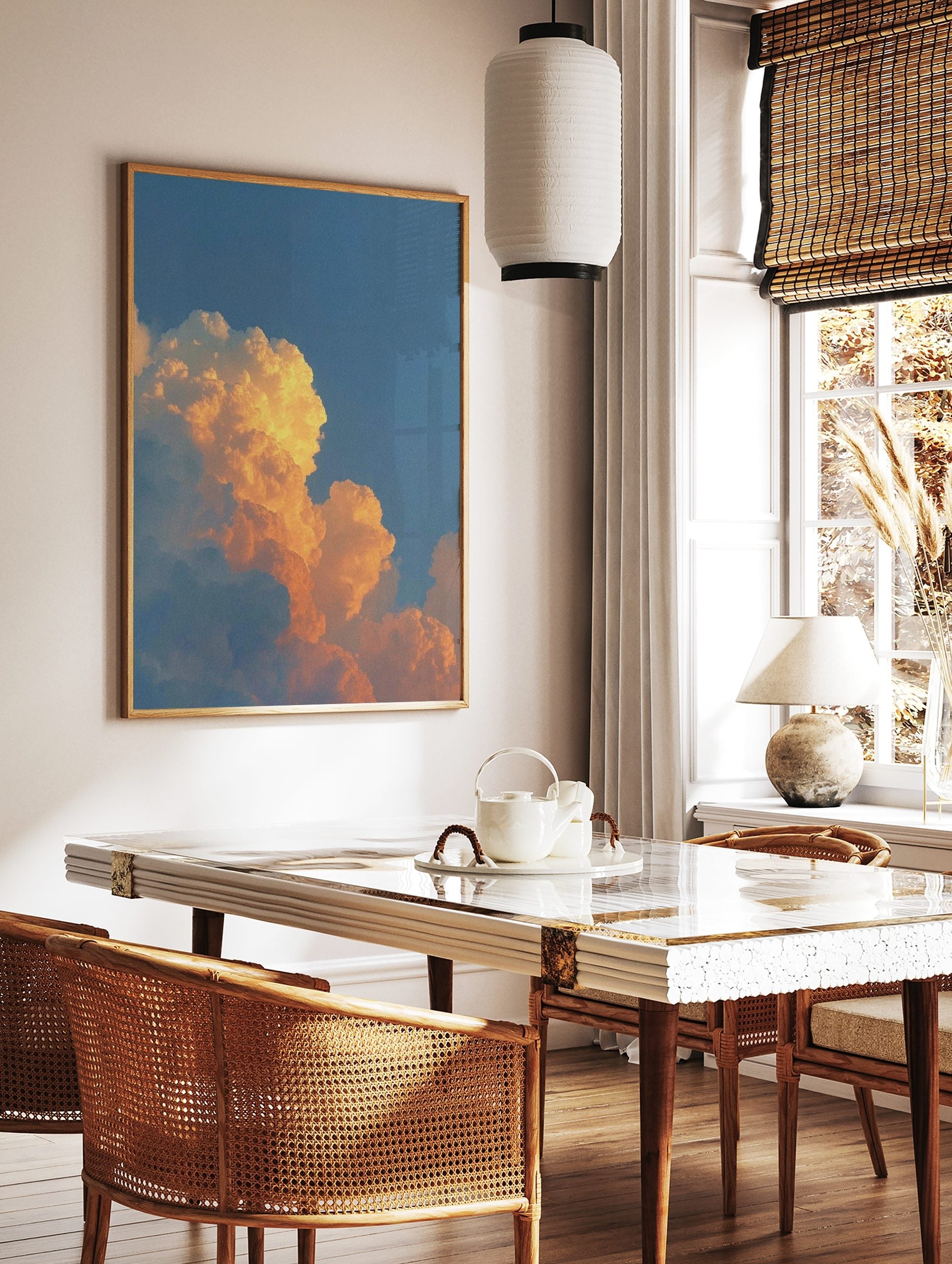 Dramatic orange and golden cumulus clouds against a clear blue sky during sunset, in a styled room mockup