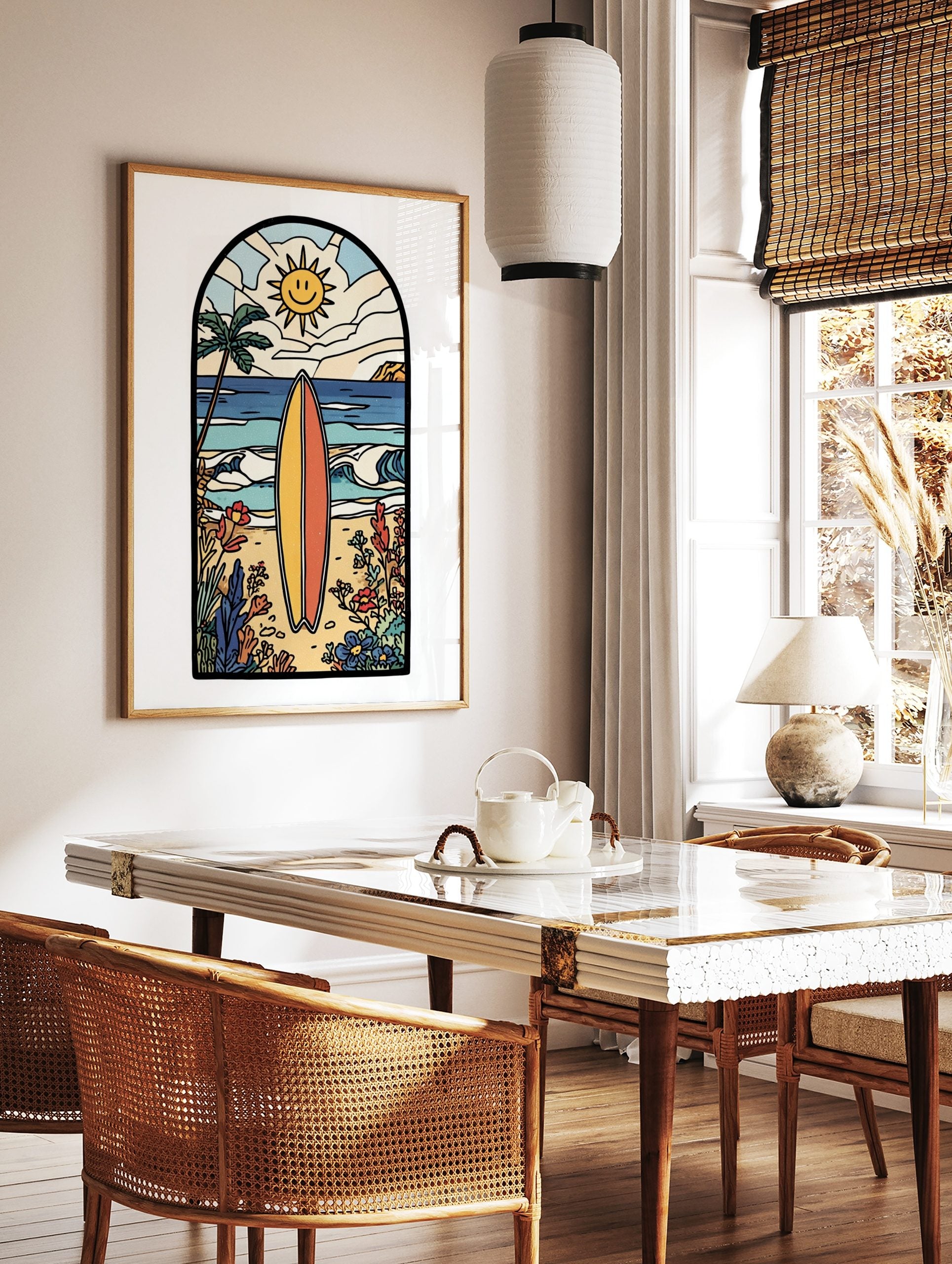 Illustrative beach scene art print with a yellow and orange surfboard, palm tree, smiling sun, and, in a styled room mockup