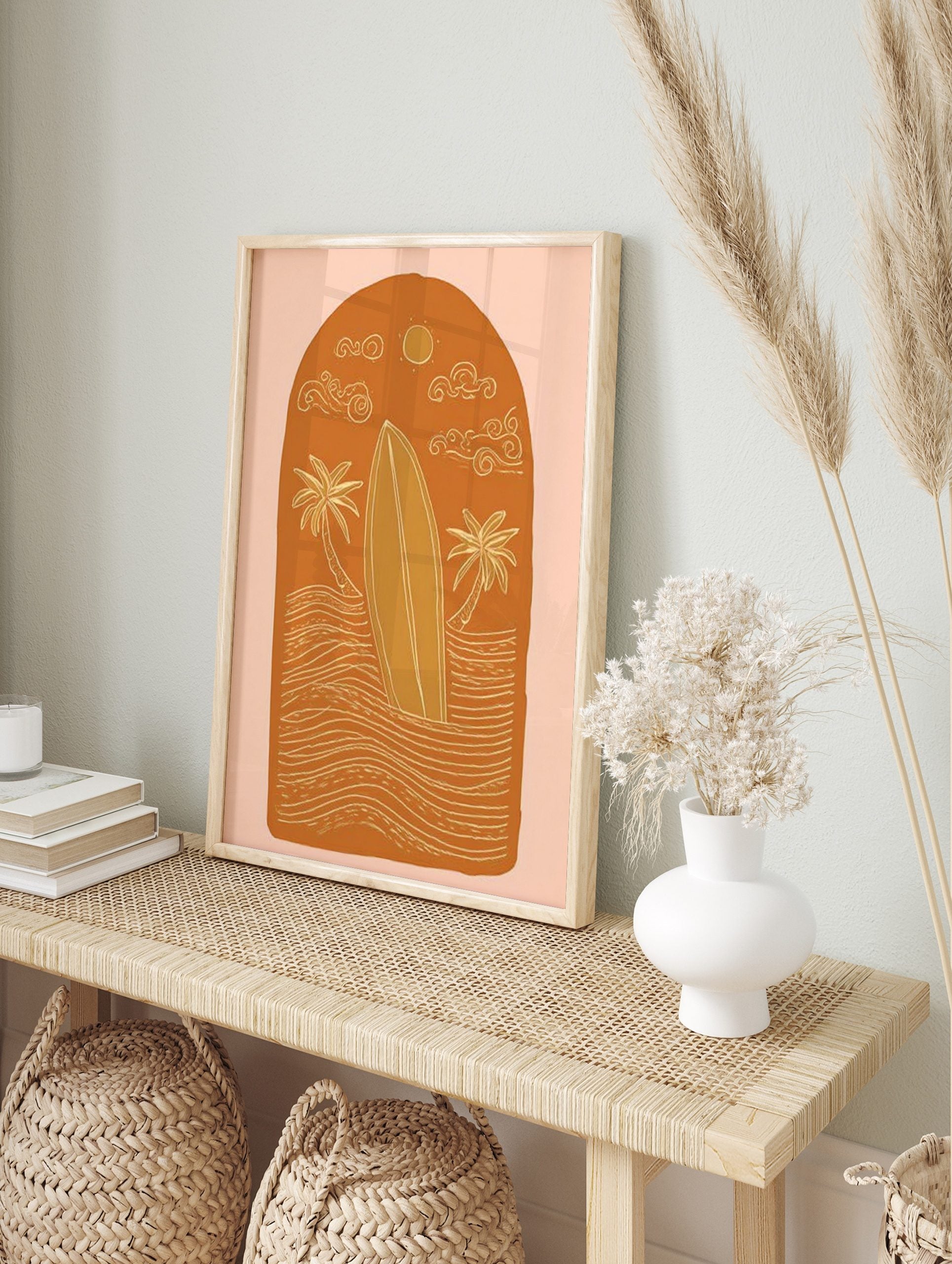 Illustrative surfboard, two palm trees, waves, sun, and clouds in an arched orange design, in an alternate framed mockup