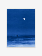 Minimalist blue night sea art print featuring a lone surfer gliding under a large full moon