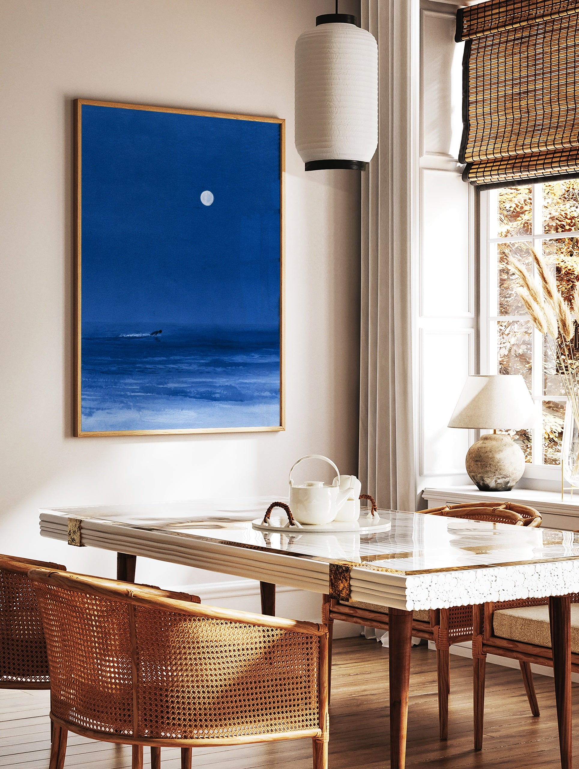 Minimalist blue night sea art print featuring a lone surfer gliding under a large full moon, in a styled room mockup