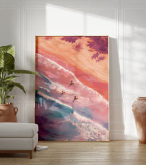Aerial view poster of three surfers on surfboards in pastel pink and blue ocean waves with sandy beach and palm trees. - Image 3