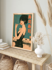 Illustrative poster of a woman eating sushi with chopsticks and Japanese kanji text on a teal, in an alternate framed mockup