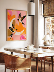 Two swallows in flight against a painterly pink and orange background, abstract bird wall art print, in a styled room mockup