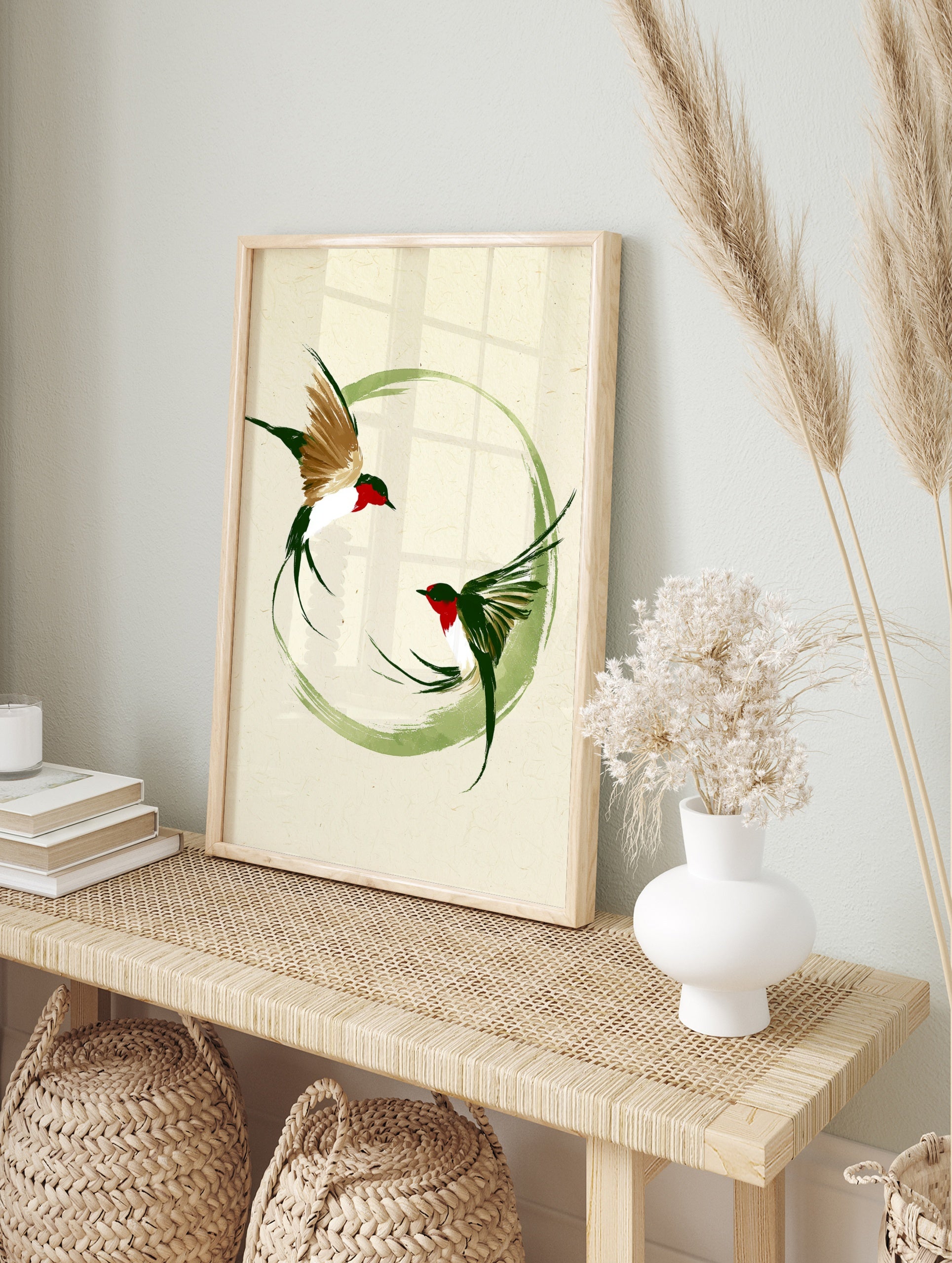Japanese style ink brush painting of two swallow birds flying within a green circular, in an alternate framed mockup