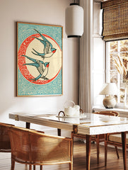 Vintage illustrative art print of two swallow birds flying inside a decorative circular frame on a, in a styled room mockup
