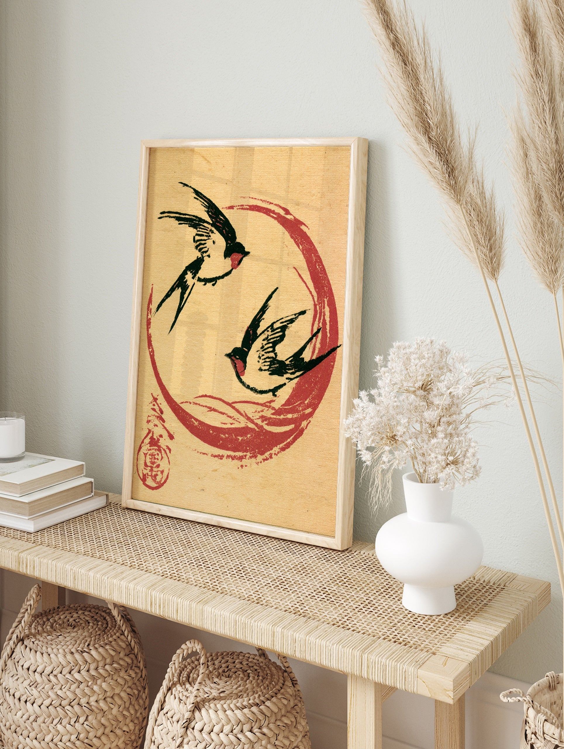 Two black swallows flying within a red circle on a tan paper background, Japanese-style art, in an alternate framed mockup