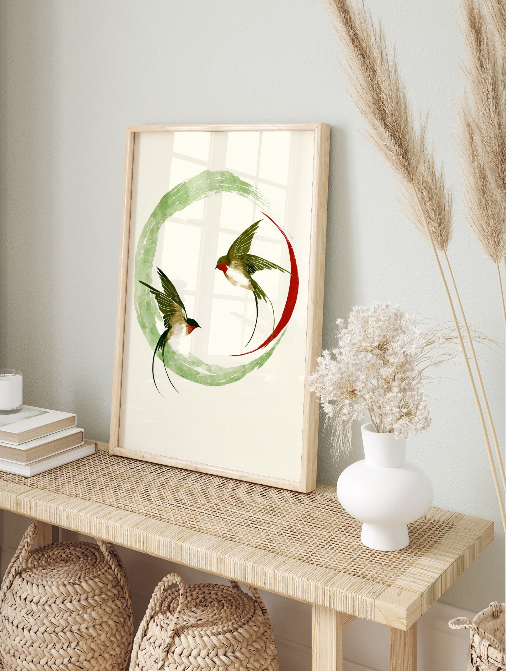 Swallow wall art print with two birds in flight inside a green ink wash circle and red arc on, in an alternate framed mockup