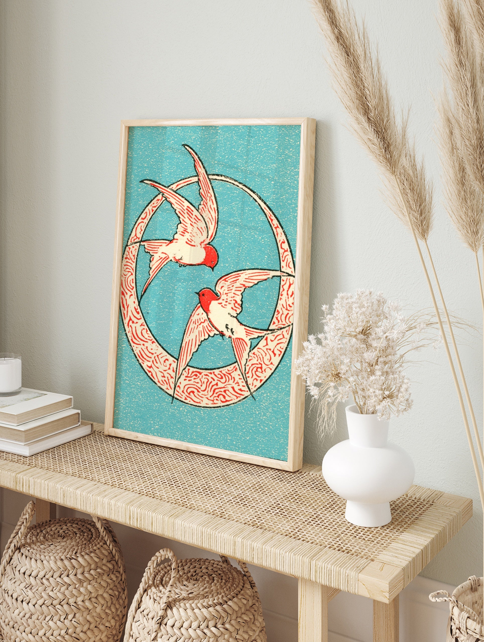 Two swallows in red and cream flying inside a circular patterned frame on a blue background, in an alternate framed mockup