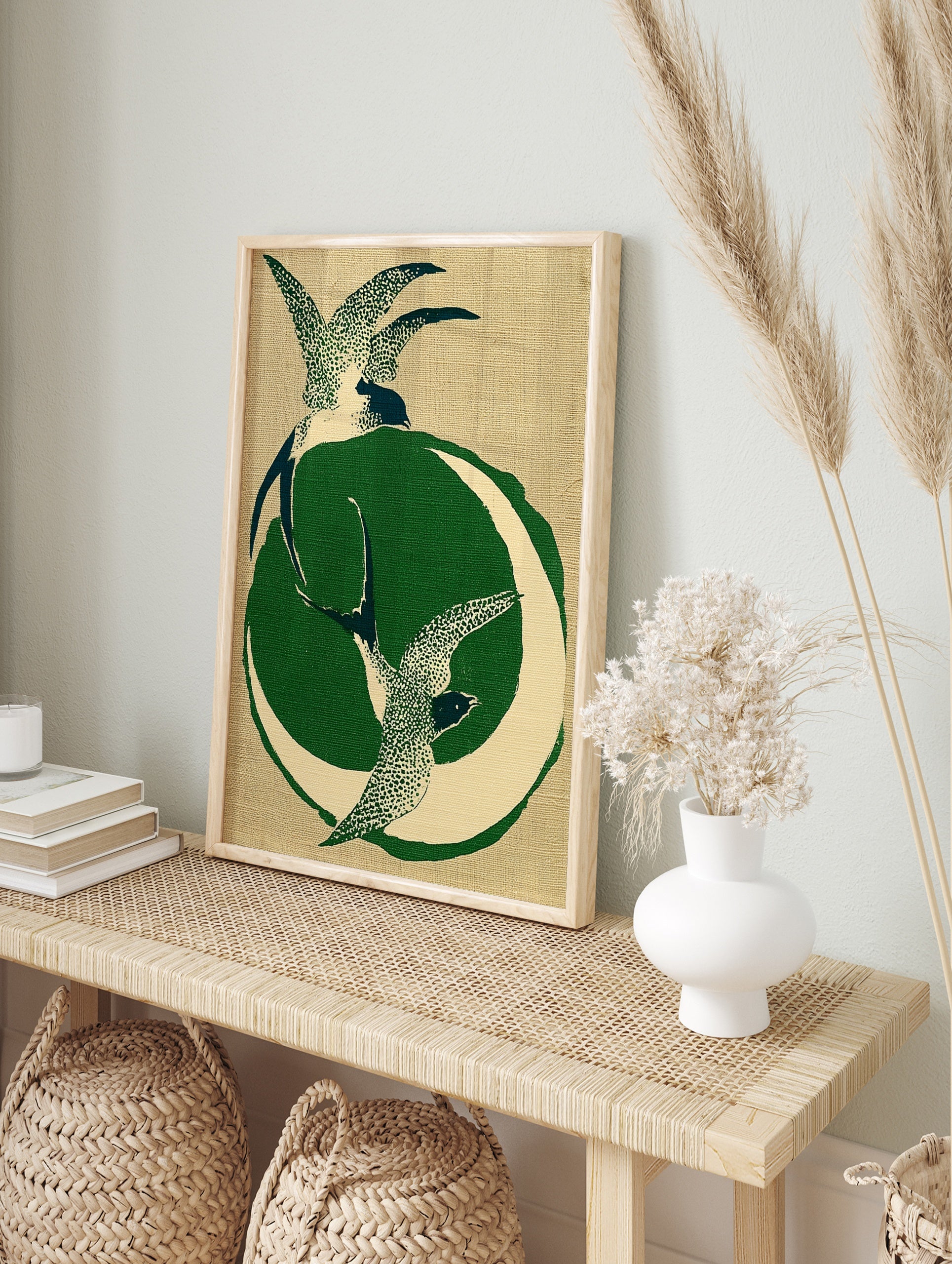 Stylised illustration of two swallows in flight with a green crescent moon on a textured tan, in an alternate framed mockup