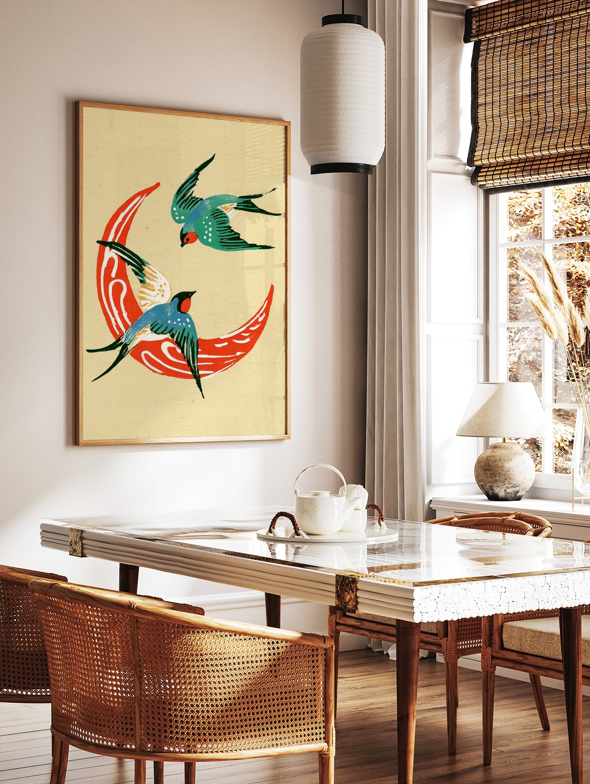 Two swallows flying around a red crescent moon, illustrative style print on cream background, in a styled room mockup