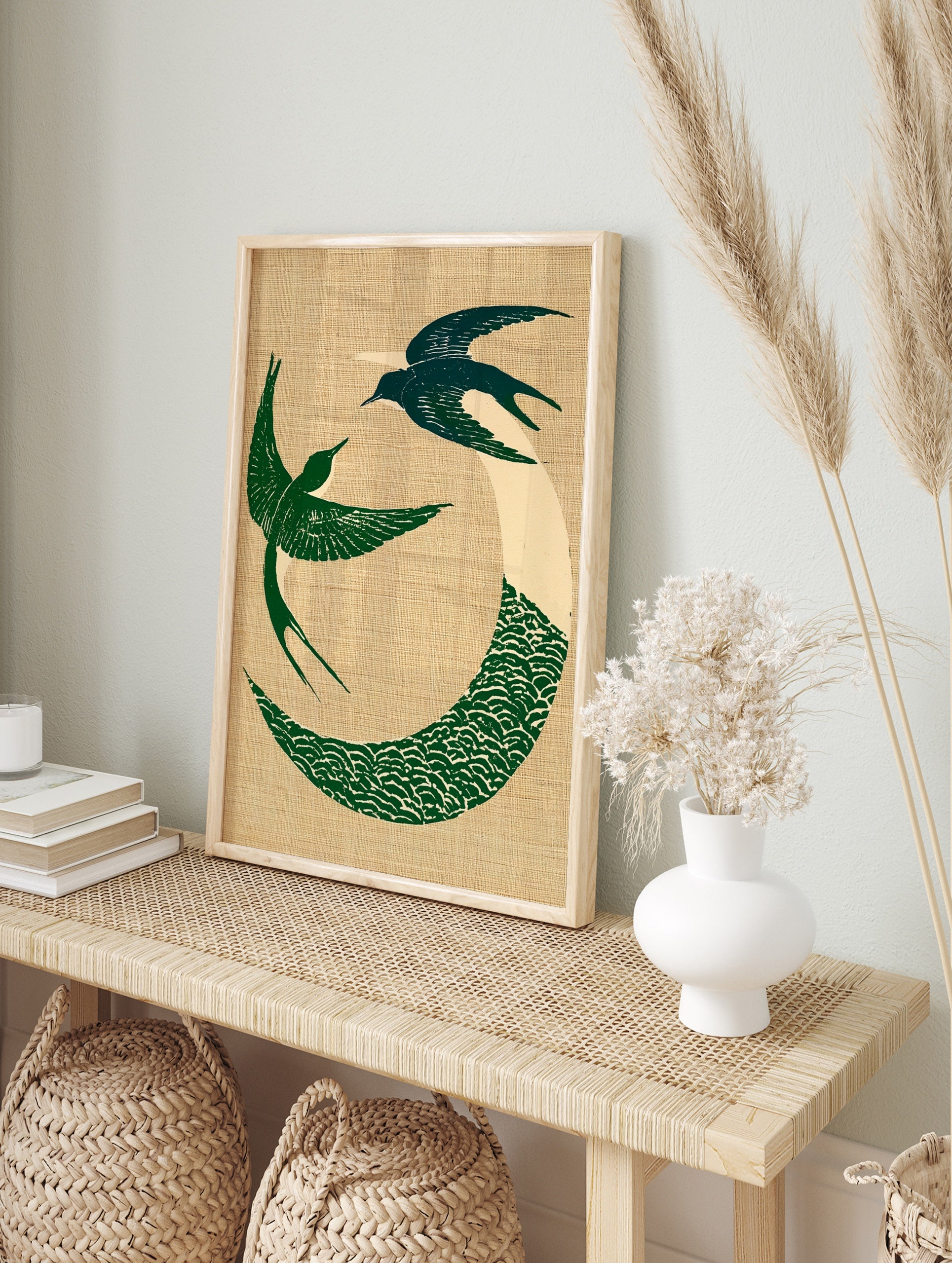 Circular art print of two green swallows in flight with a wave motif on a textured beige, in an alternate framed mockup