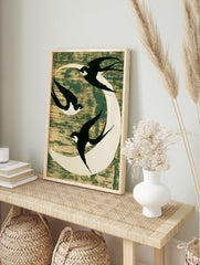 Three black swallows flying against a white moon on a textured dark green background, in an alternate framed mockup