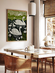 Green and white linocut-style print of two swans and two cygnets swimming in a lake with water, in a styled room mockup