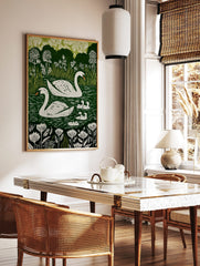 Illustrative print of two white swans and five cygnets on a dark green lake with white flowers and, in a styled room mockup