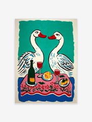 Illustrative print of two white swans with red beaks over a pink floral dinner table with wine and food