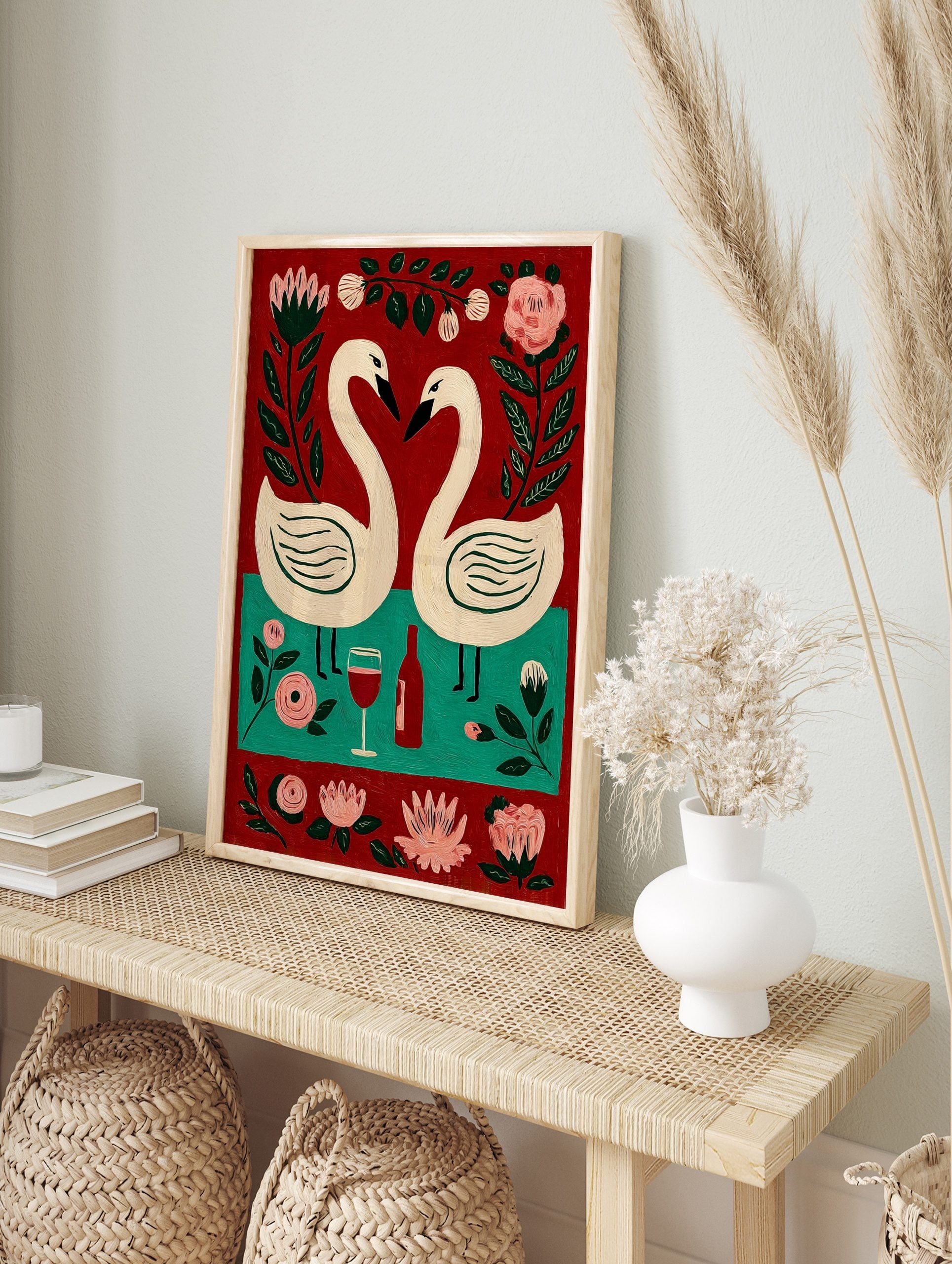 Folk art painting of two white swans forming a heart, red wine bottle, glass, and pink, in an alternate framed mockup