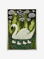 White swan with four cygnets swimming on green water, surrounded by green reeds and white flowers