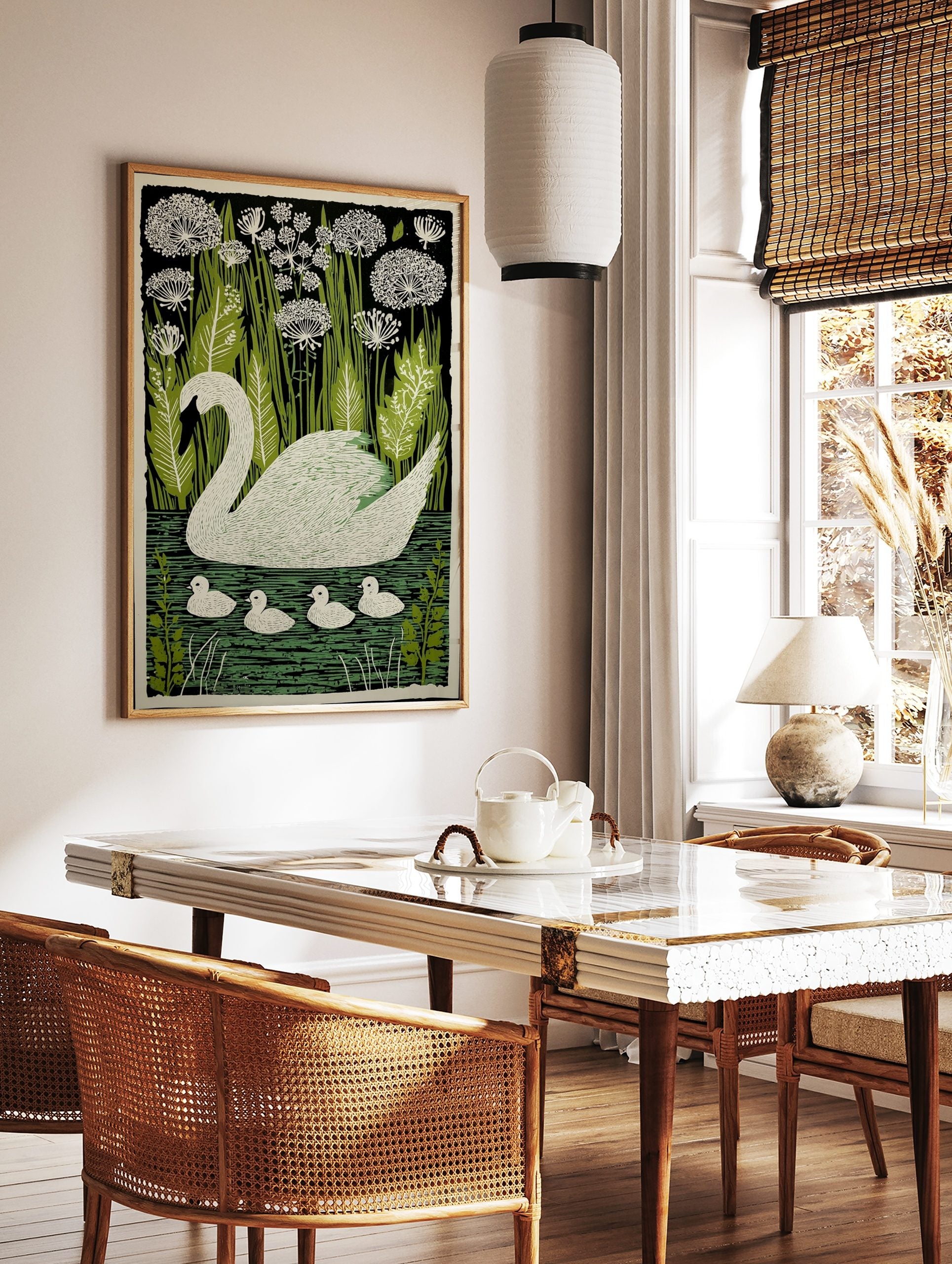 White swan with four cygnets swimming on green water, surrounded by green reeds and white flowers, in a styled room mockup