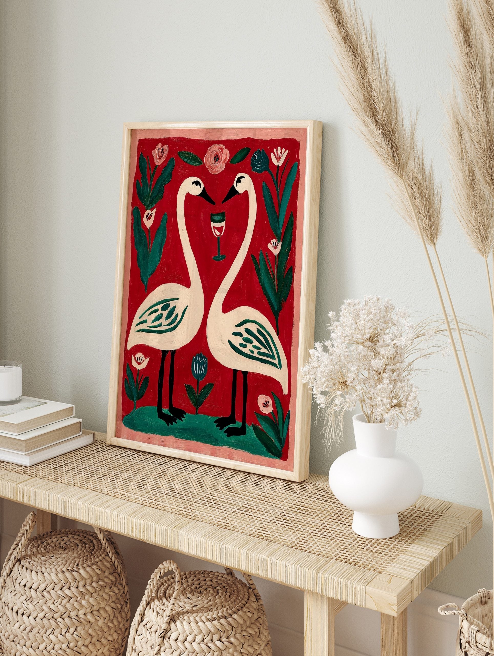 Illustrative print of two white swans forming a heart, with a wine glass, pink and blue, in an alternate framed mockup
