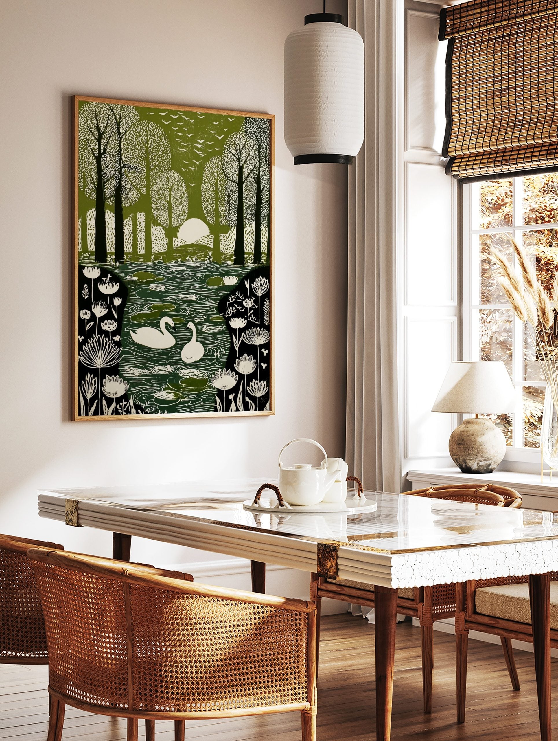 Green and white illustrative print of swans on a pond in a forest with birds flying overhead and sun, in a styled room mockup