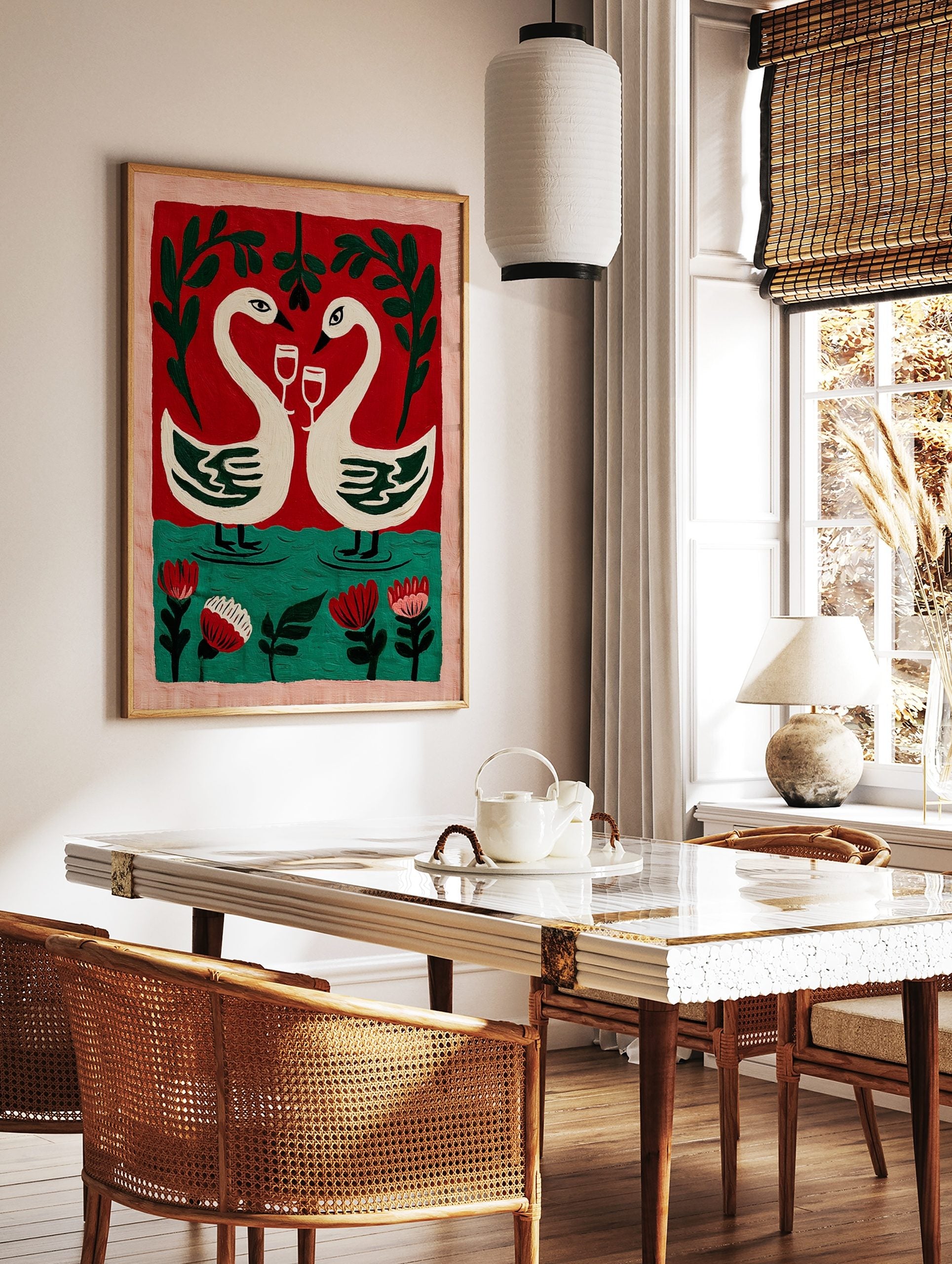 Illustrative wall art of two white swans with wine glasses, forming a heart, against a red and, in a styled room mockup