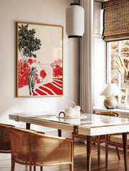 Tabby cat on path looking at red bushes and black trees in illustrative landscape print, in a styled room mockup