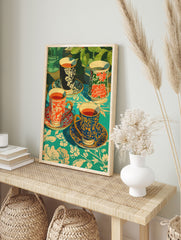 Poster of four decorative tea cups with various patterns (red, blue, black) on a vibrant teal floral tablecloth with green plants in background. - Image 4