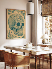 Teal ornate sugar skull illustration with floral patterns and decorative vines on a tan paper, in a styled room mockup